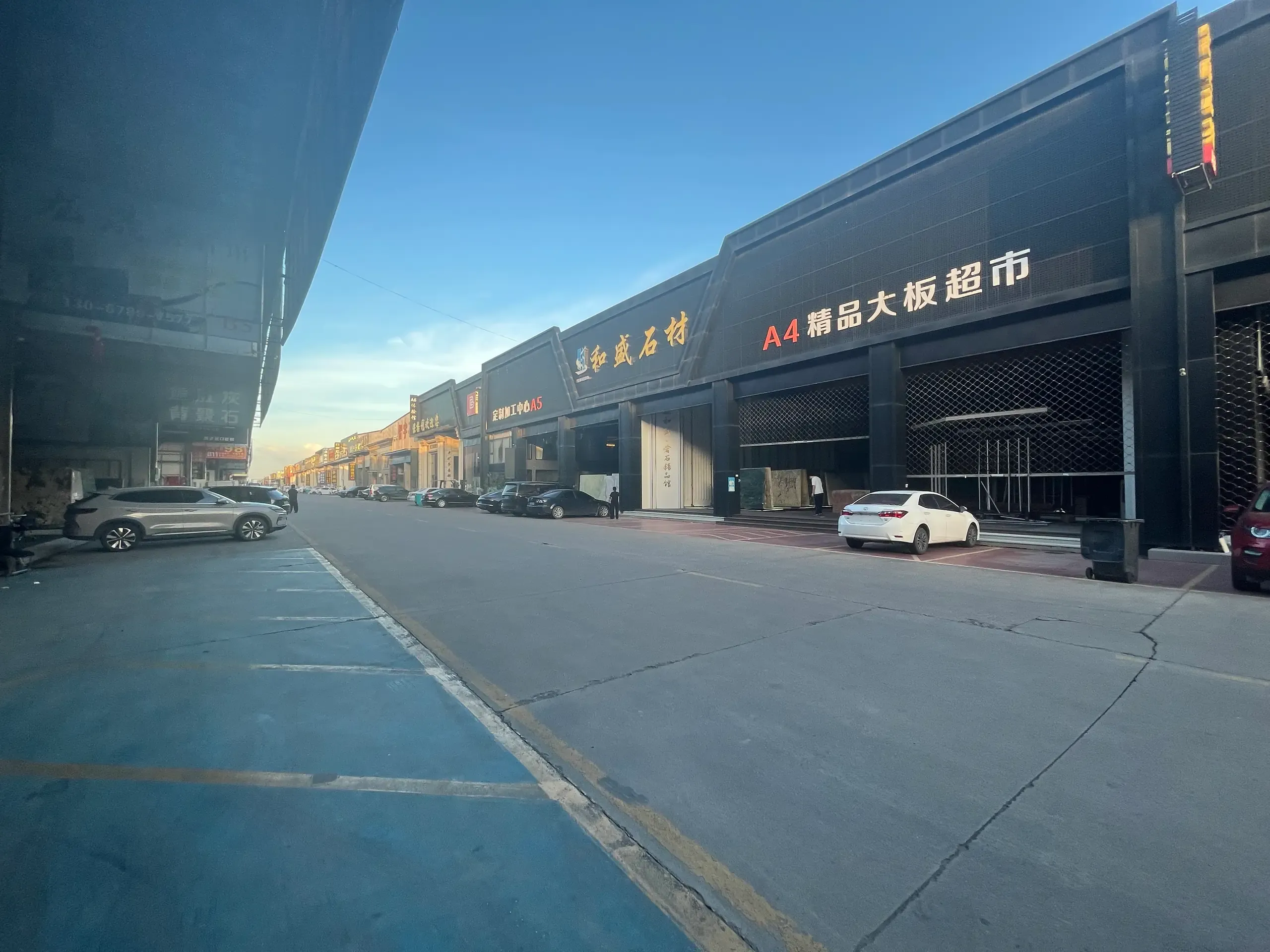 杭州和盛石材总部门店沿街门面实景,招牌「和盛石材」与「A4 精品大板超市」「定制加工中心 A5」,总部位于杭州钱塘区钱塘江石材市场二期 A4–A6,成立于 1998 年